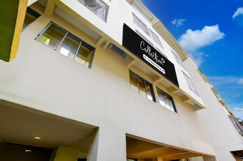 a white building with a black sign on it at Collection O Vangani Railway Station Hotel Chadha in Mumbai