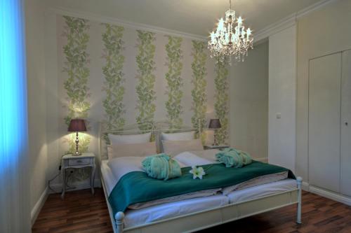 a bedroom with a bed with a chandelier at Hotel Zum Goldenen Stern in Prüm