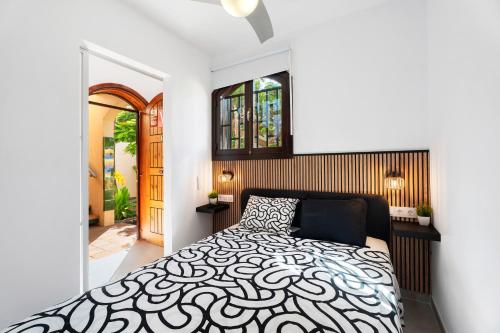 a bedroom with a bed with a black and white comforter at Casa Tagoro Dream in Costa Del Silencio