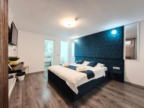 a bedroom with a large bed with a blue wall at Gaste Haus Ober in Braşov