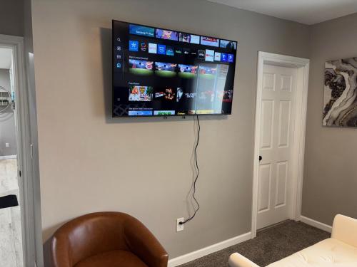 a room with a flat screen tv on a wall at No Chores, 10min to downtown and 25min to Niagara Falls in Buffalo