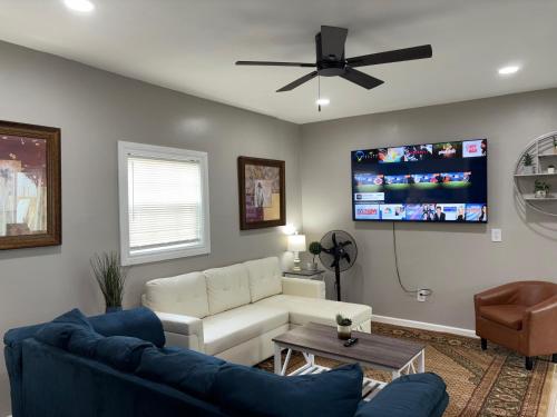 a living room with a couch and a flat screen tv at No Chores, 10min to downtown and 25min to Niagara Falls in Buffalo
