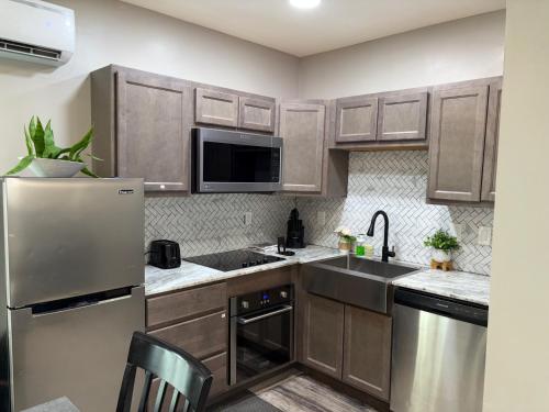 a kitchen with wooden cabinets and a stainless steel refrigerator at No Chores, 10min to downtown and 25min to Niagara Falls in Buffalo