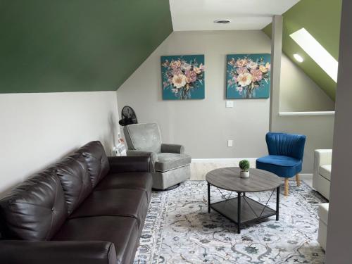 a living room with a leather couch and a chair at No Chores, 10min to downtown and 25min to Niagara Falls in Buffalo