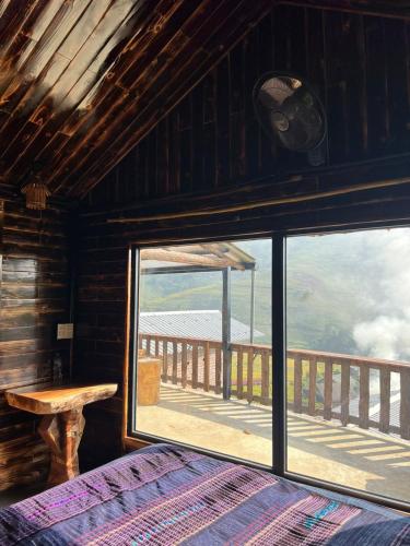a bedroom with a view of the ocean from a window at SaPa Big Tree Hmong Homestay in Sa Pa