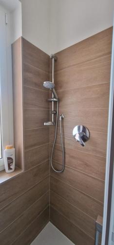 y baño con ducha y pared de madera. en Kamira's Home, en San Remo