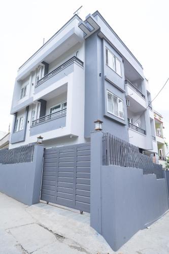 a white house with a fence in front of it at Bright & Cozy 2BHK, Peaceful Stay Close To Thamel & Swayambhu in Kathmandu