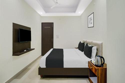 a bedroom with a black and white bed and a tv at HOTEL O HAPPY PLACE HOTEL & RESORT in Gaya