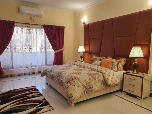 a bedroom with a large bed with a large headboard at Tom's Villa House in Islamabad