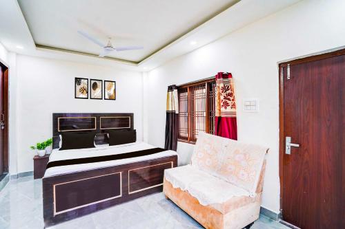 a bedroom with a bed and a chair in it at Hotel O Ashiyana in Lucknow