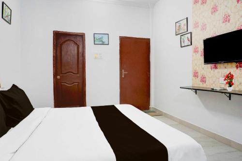 a bedroom with a white bed and a tv at Hotel O Baner Near Mumbai Pune Highway in Pune