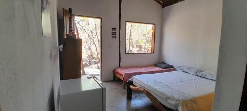 ein kleines Zimmer mit zwei Betten und einem Fenster in der Unterkunft Chalés Santo Verde 2 in Goiás