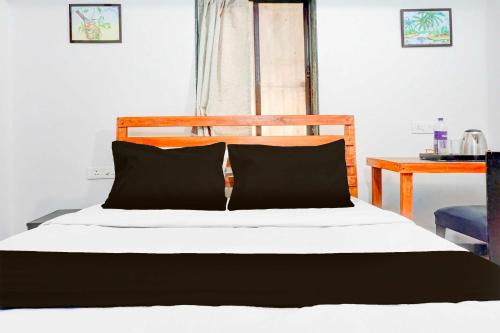 a bed with black and white sheets and a table at Hotel O Baner Near Mumbai Pune Highway in Pune