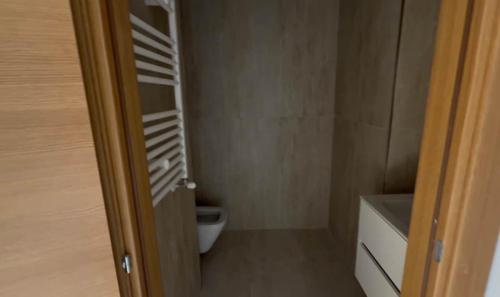 a bathroom with a toilet and a door open at Luxus Apartment in Zarzis