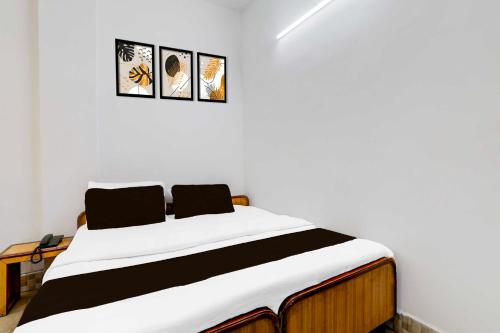 a bed in a room with three pictures on the wall at Collection O Insaf Nagar Munshipuliya in Lucknow
