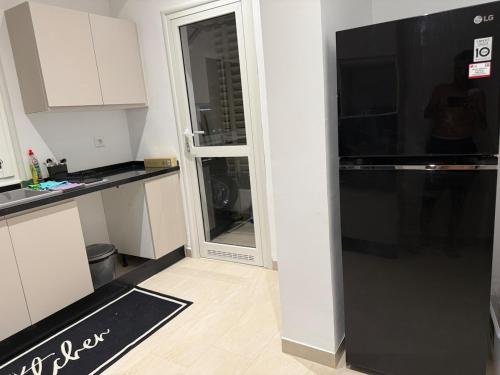 a kitchen with a black refrigerator and a window at Luxus Apartment in Zarzis