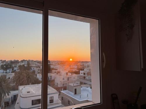 a view from a window of a city at sunset at Luxus Apartment in Zarzis