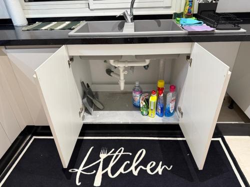 an open cabinet under a sink in a kitchen at Luxus Apartment in Zarzis