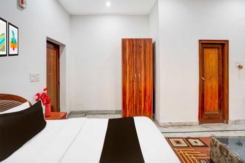 a bedroom with a bed and a wooden door at Collection O Krishna Nagar Chowk Near ONGC in Dehradun