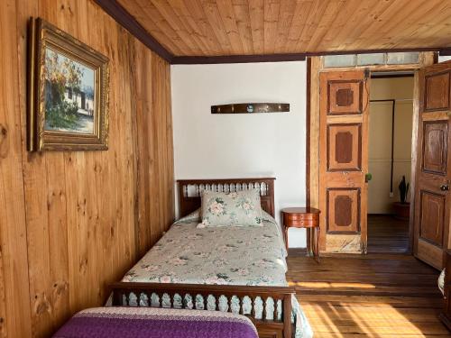 una camera da letto con un letto in una stanza di legno di Hostal Casa Rosada, Valle del Elqui a Rivadavia
