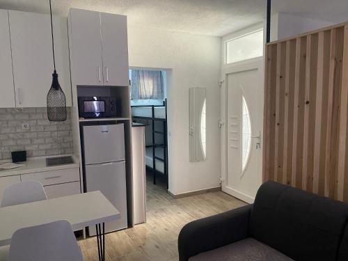 Una cocina y sala de estar con sofá y microondas. en Apartmani Zilic, en Mostar