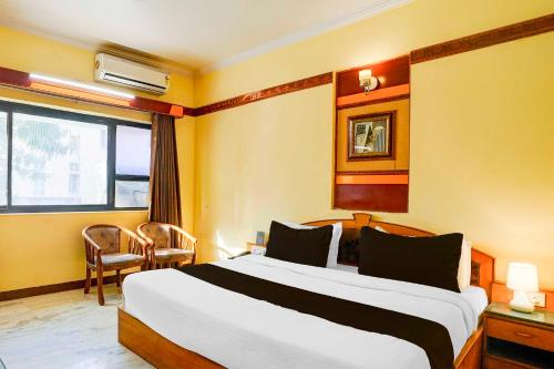 a hotel room with a large bed and a window at Townhouse Oak Jaipur Arya Square Shopping Mall in Jaipur