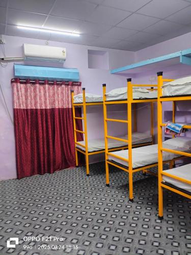 a room with three bunk beds and a curtain at Vishwanath home stay dormitory in Varanasi