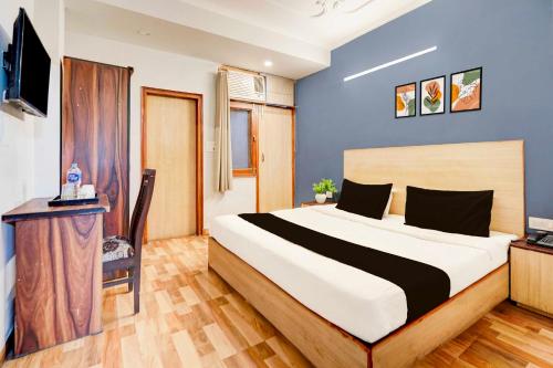 a bedroom with a large bed and a television at Hotel O Sector 20 Noida in Noida