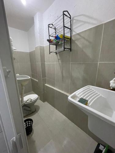 a bathroom with a tub and a toilet and a sink at Kitnet Dream House 2 in Bayeux