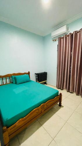 ein Schlafzimmer mit einem Bett mit grüner Bettwäsche und einem Fenster in der Unterkunft Homestay setiu in Setiu