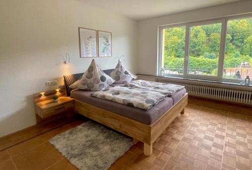 a bedroom with a bed and a large window at Whirlpool, Billiard, Sauna! Ferienhaus Lacher in Baiersbronn