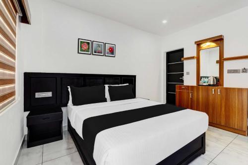 ムンナルにあるHotel O Chithirapuram View Point Munnarのベッドルーム1室(大型ベッド1台、木製キャビネット付)