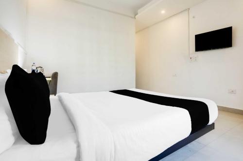 a bedroom with a white bed and a television at Hotel O Gol Park Atala in Prayagraj