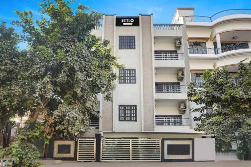 a tall white building with a sign on it at Hotel O Gol Park Atala in Prayagraj
