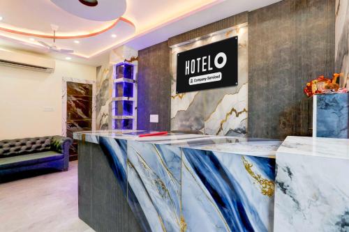 a lobby with a counter with a hotel sign on the wall at Hotel O Om Prakash Sabhasad Nagar in Prayagraj