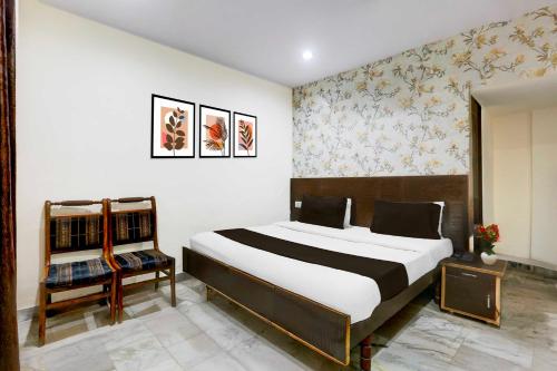 a bedroom with a large bed and a chair at Collection O Subhani Building in Ludhiana