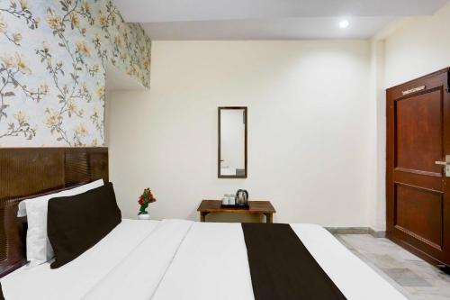 a bedroom with a large bed and a mirror at Collection O Subhani Building in Ludhiana