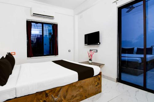 a bedroom with a bed and a large window at Collection O New Town in Kolkata