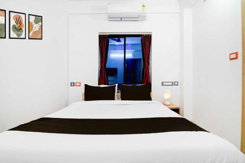 a bedroom with a white bed and a window at Collection O New Town in Kolkata