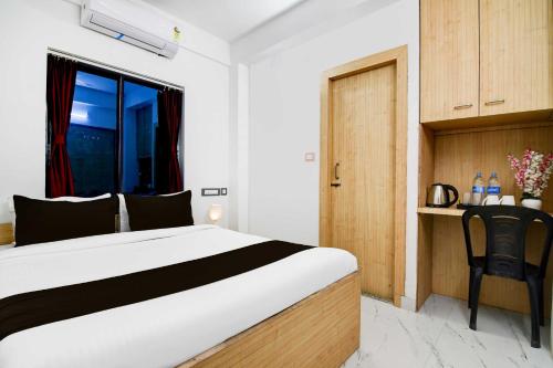 a bedroom with a bed and a desk with a chair at Collection O New Town in Kolkata