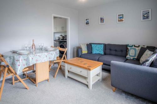 a living room with a couch and a table at Langcliffe Park - 2 Bedroom Chalet - Mumbles in Swansea