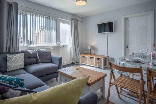 a living room with a couch and a table at Langcliffe Park - 2 Bedroom Chalet - Mumbles in Swansea