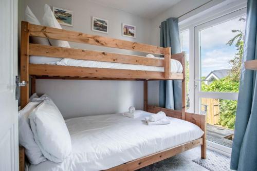 a bedroom with two bunk beds and a window at Langcliffe Park - 2 Bedroom Chalet - Mumbles in The Mumbles