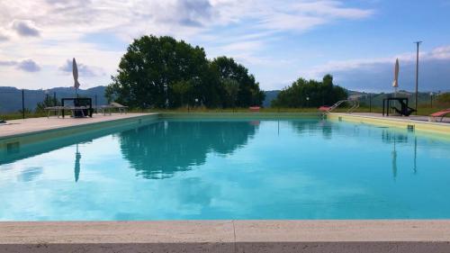 a large swimming pool with blue water at affittacamere b&b l'aurora Montelparo in Montelparo