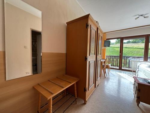 a room with a bench and a cabinet and a balcony at Simplex Stays Hotel Lauer in Bad Soden-Salmünster