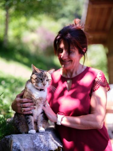 a woman sitting on a rock holding a cat at Chalet LE VAL NESS in La Côte dʼArbroz