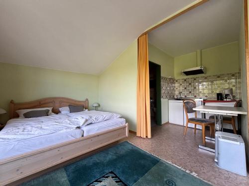 a bedroom with a bed and a table and a kitchen at Simplex Stays Hotel Lauer in Bad Soden-Salmünster