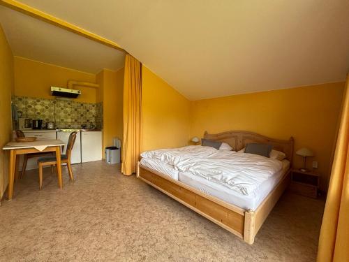 a bedroom with a bed and a table and a kitchen at Simplex Stays Hotel Lauer in Bad Soden-Salmünster