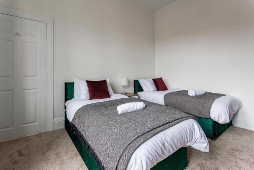 ウォールセンドにある2 Br Home Perfect For Short And Long Term Stayの白と緑の部屋のベッド2台