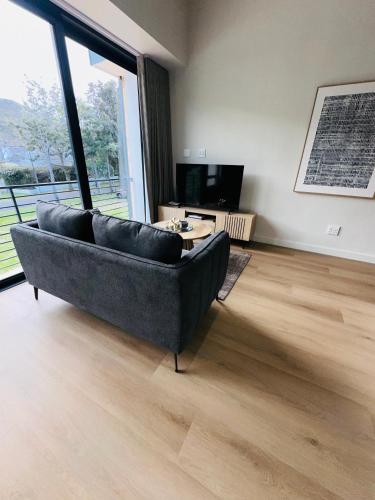 a living room with a couch and a television at Valley's Embrace Apartment 7 in Hermanus